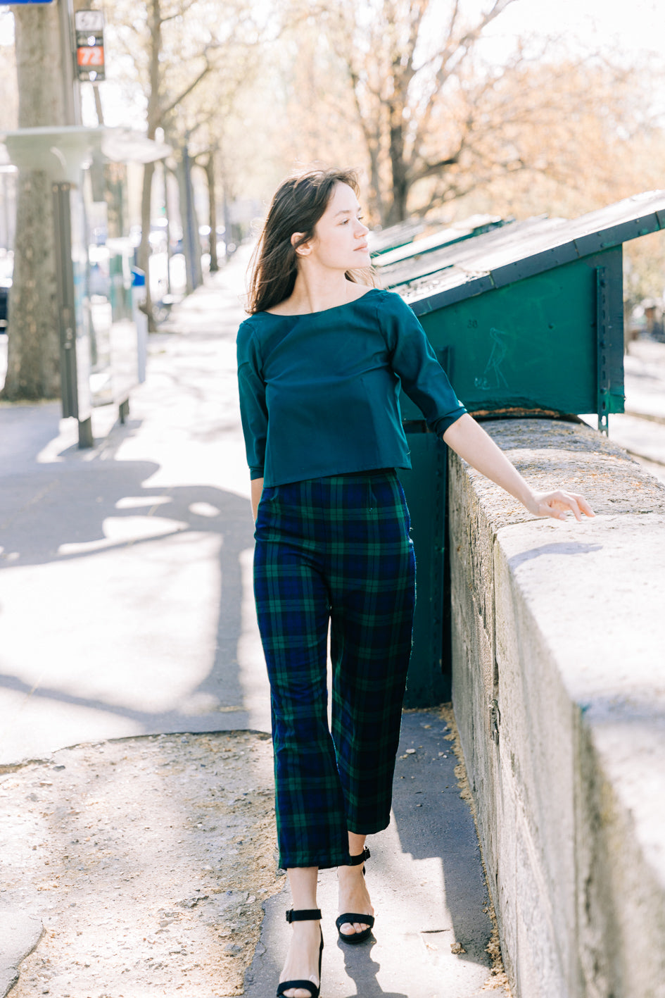 Ensemble 'Charlotte' avec pantalon en coton à carreaux bleu et vert et top dos nu en soie vert foncé, porté par un modèle. Vue complète de face