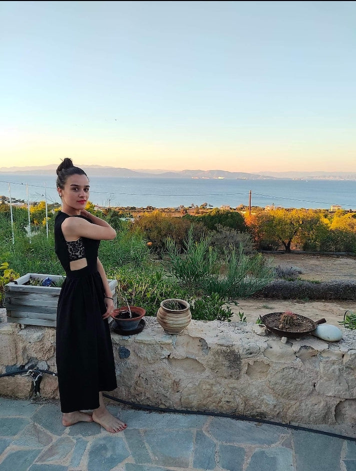 Robe Jeanne en soie noire. Vue complète de coté portée par une cliente