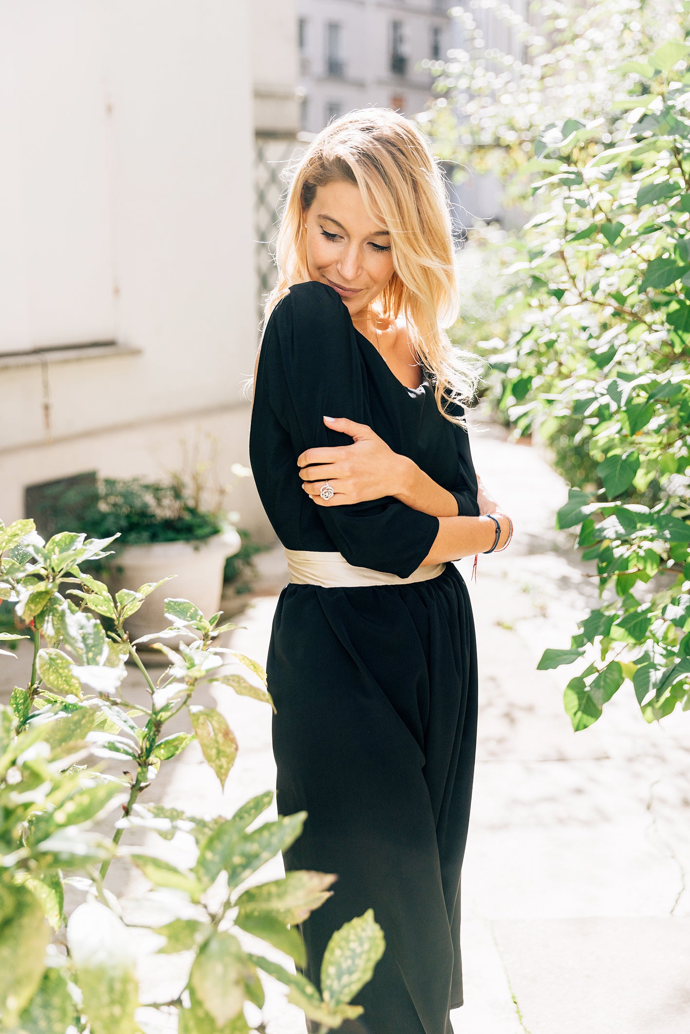 Robe 'Solene' en soie noire. Vue 3/4 de face mettant en valeur la ceinture dorée et le col rond da la robe.