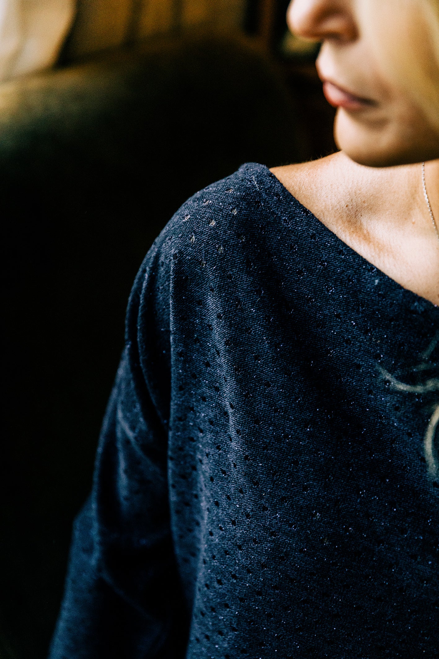 Détail des paillettes scintillantes sur le pull 'Léa' et du tissu en jersey de laine bleu marine.