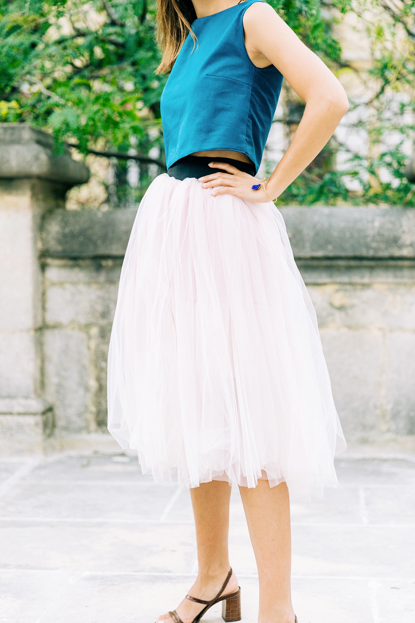 Jupe mi-longue en tulle de soie rose pastel, cintrée à la taille par une ceinture élastique noire, de l'ensemble 'Carrie