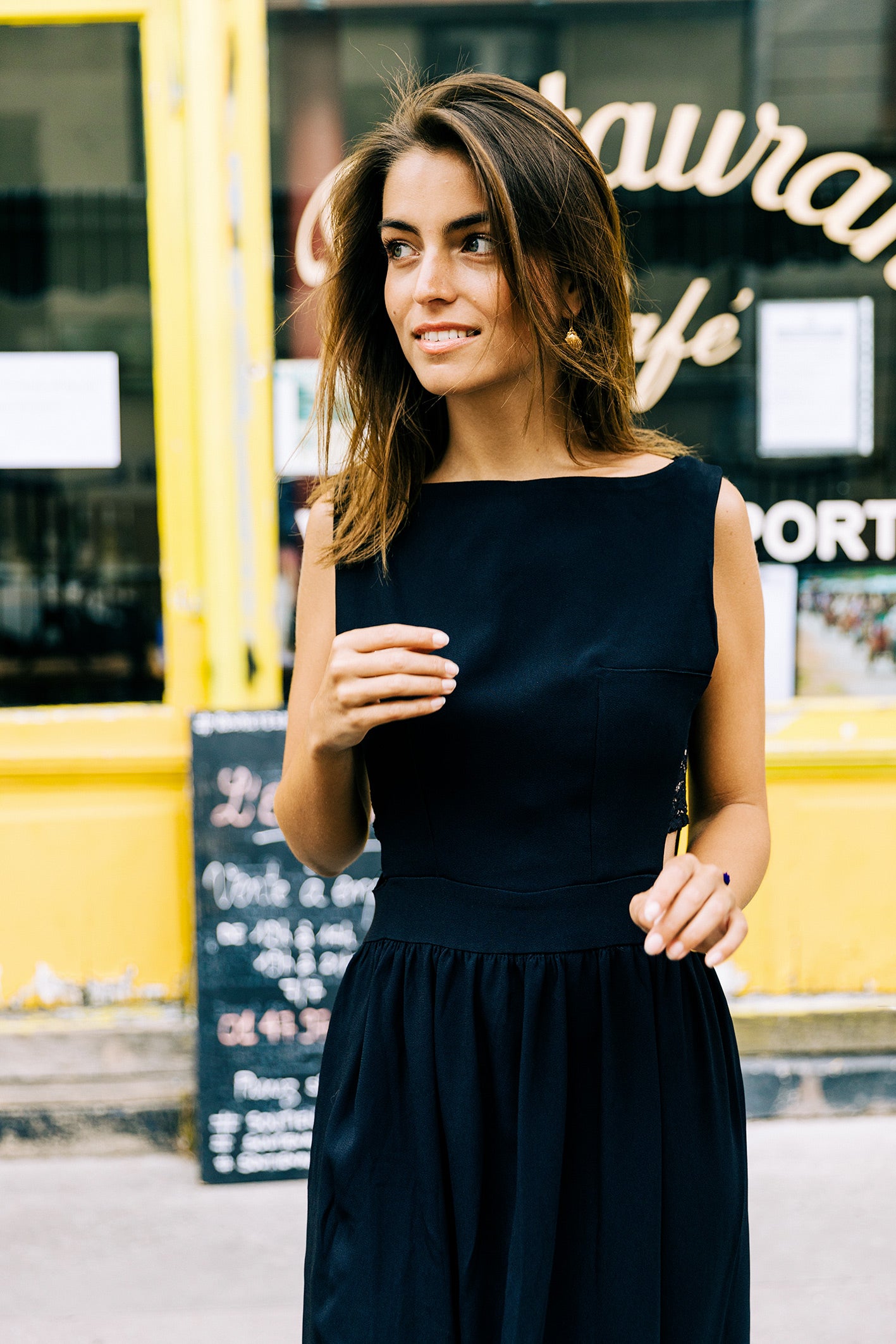 Petite robe en soie noire ajourée sur les côtés par de la dentelle brodée. 