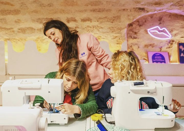 Photo des élèves en atelier couture devant leur machine à coudre 