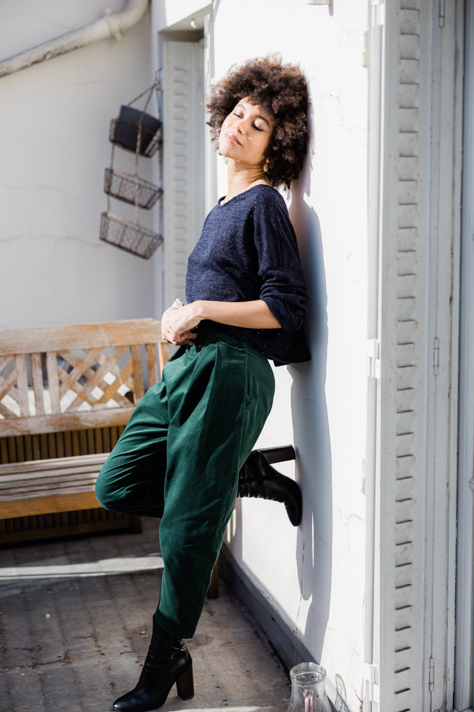 Pantalon 'Anaïs' en velours vert émeraude, coupe large, porté par un modèle. Vue de côté.