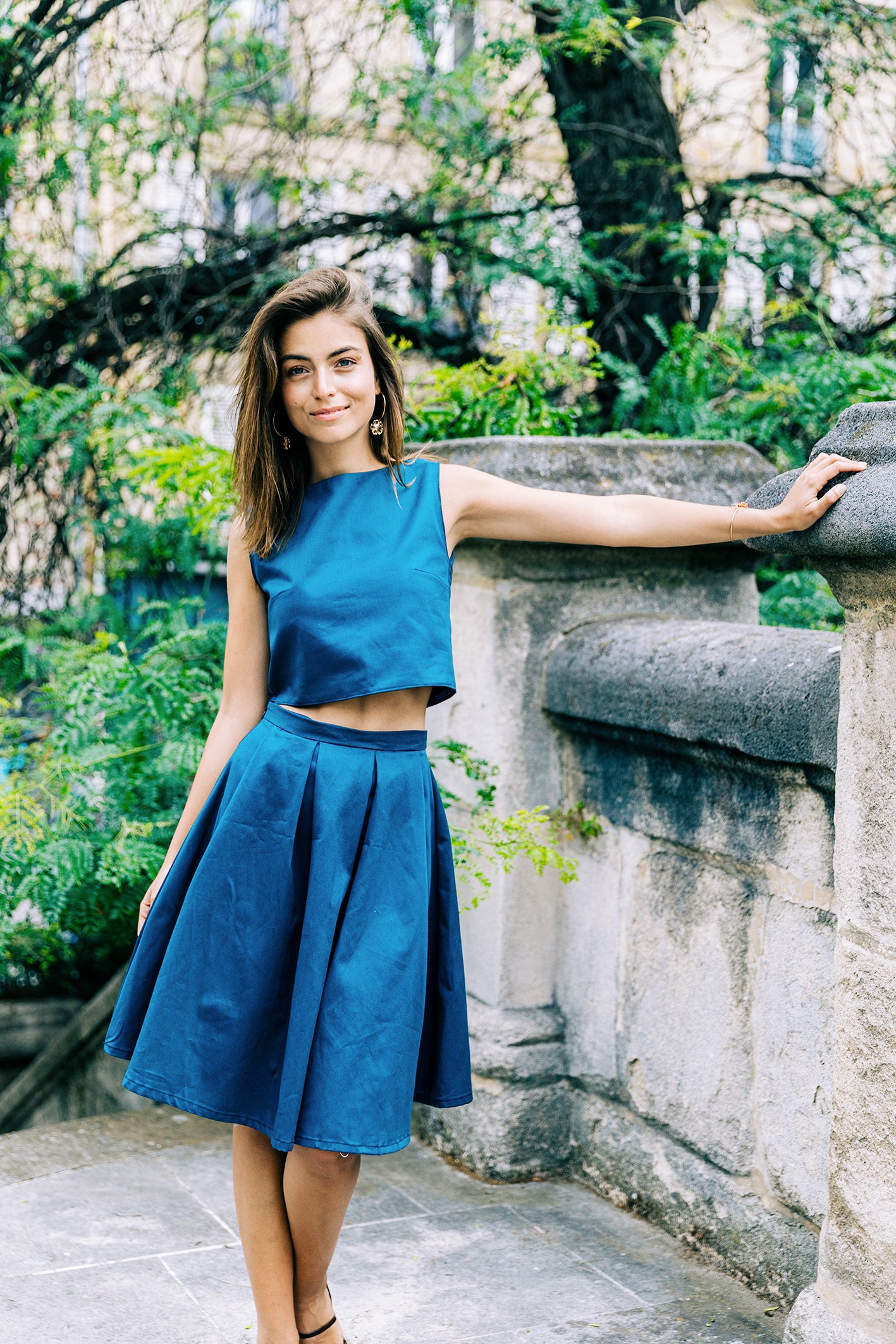 Ensemble 'Lucile' avec jupe à plis et crop-top sans manches en piqué de coton bleu, porté par un modèle, vue complète. 