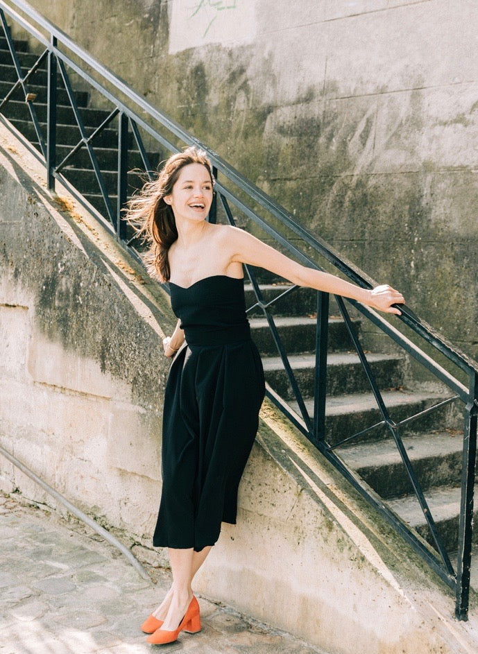 Robe 'Gabrielle' en crêpe de soie noire, vue complète avec bustier et jupe plissée en mouvement 
